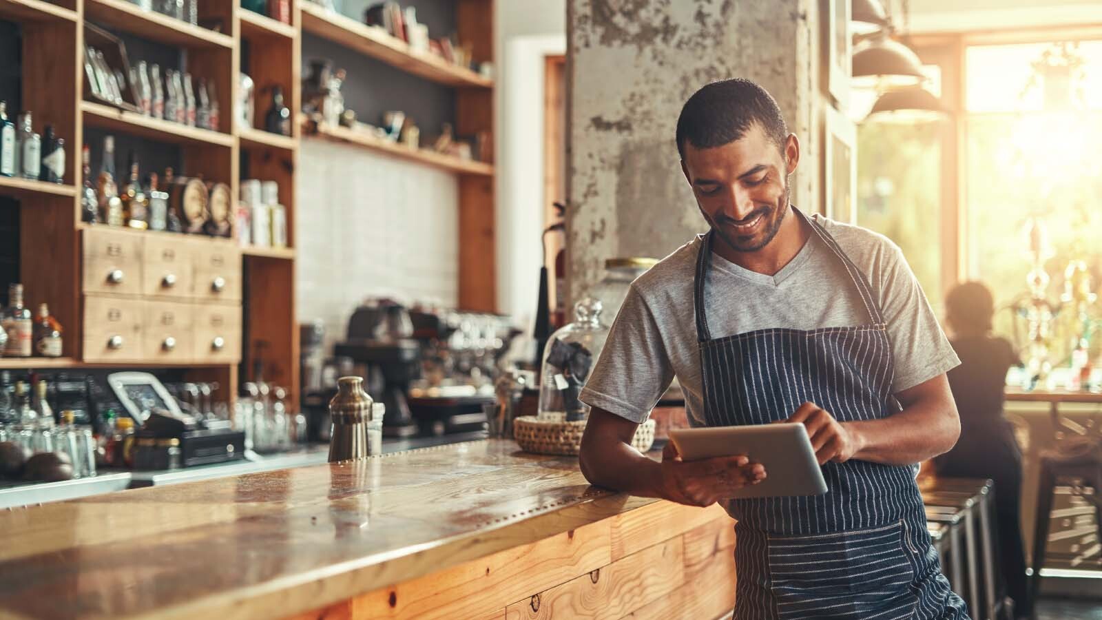 joven trabajador de restaurante mirando su tablet