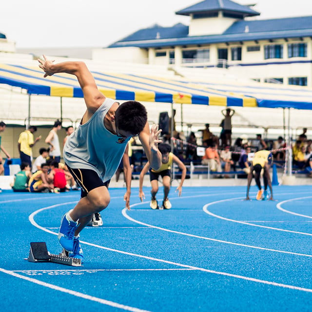 Jovem em posição de largada em uma pista de corrida