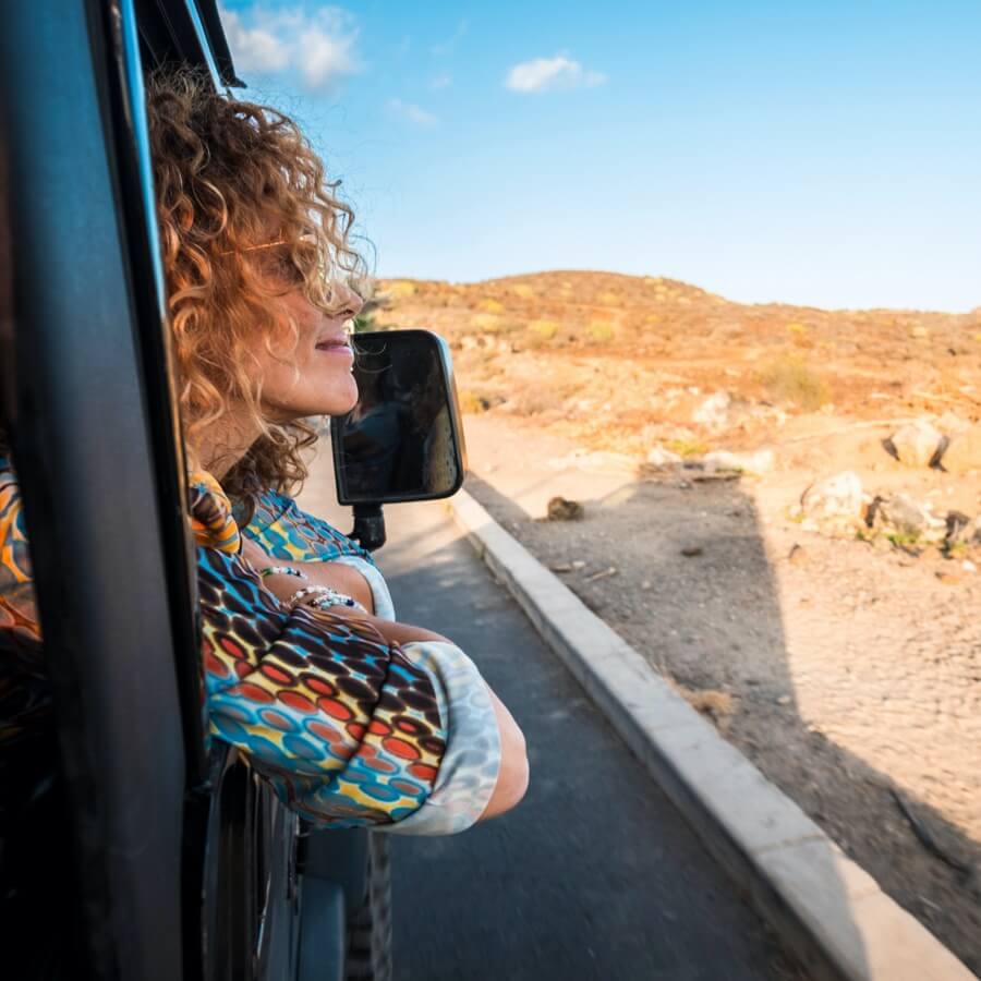 Fotografia de uma mulher viajando de carro na estrada