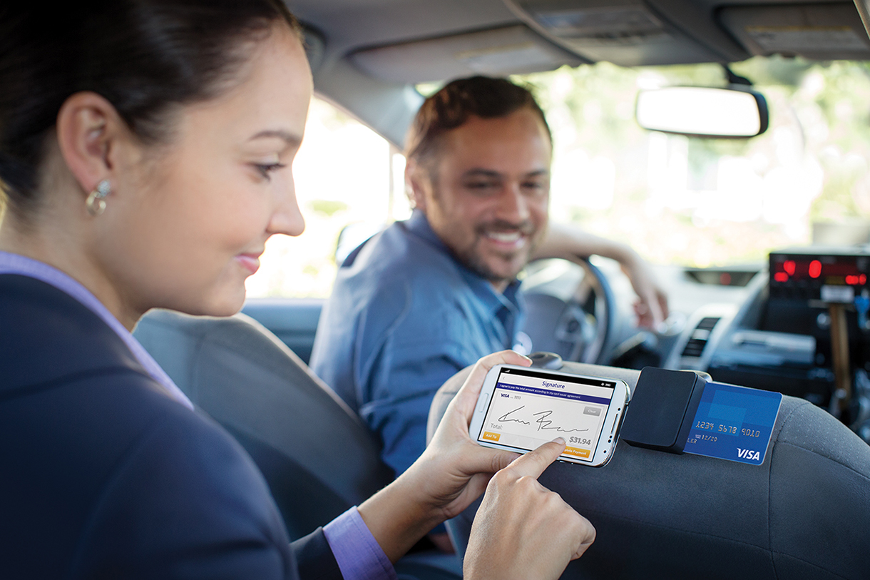 Woman using chip card in taxi to pay.