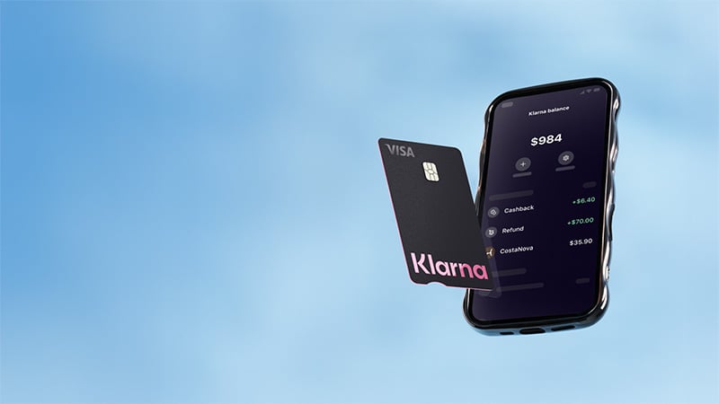 Klarna card with Visa logo next to a phone showing balance information