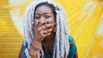 Mulher negra com rastas sorrindo