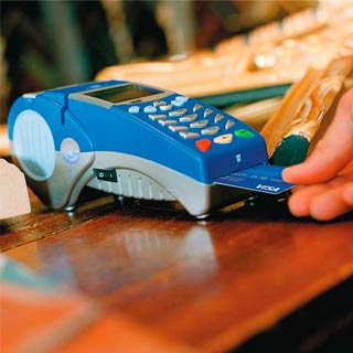 Person pays with their Visa card by inserting it into the chip reader on a payment terminal.