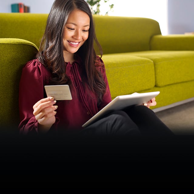 young woman using her digital tablet and credit card to bring joy to the world