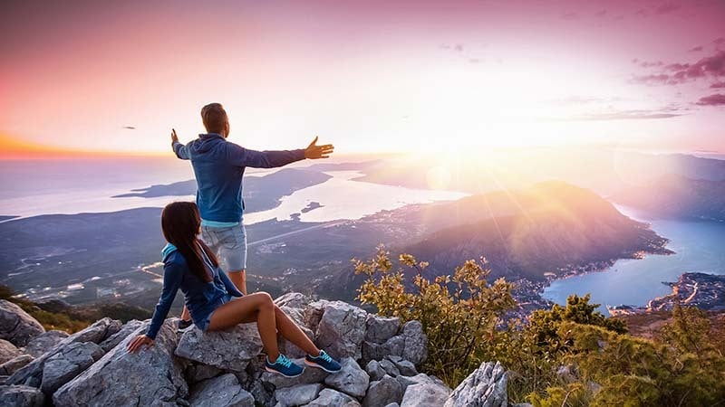 Casal apreciando uma vista bonita em cima de uma montanha