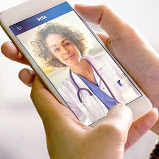 Mãos segurando um smartphone onde se vê uma médica