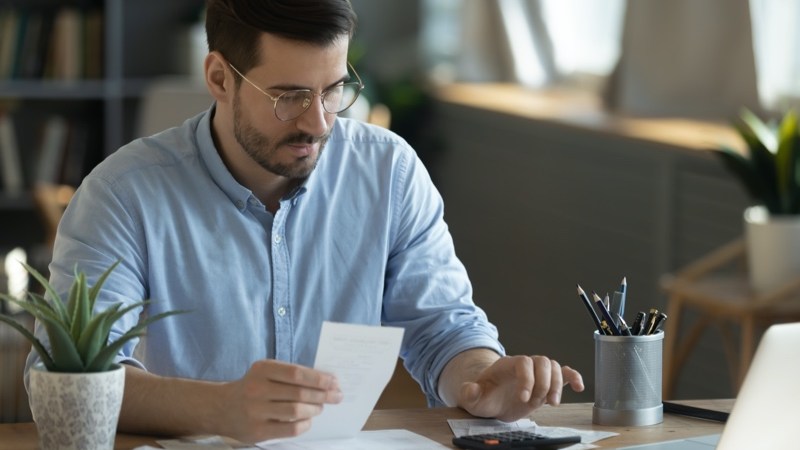 Homem com uma calculadora e alguns papéis