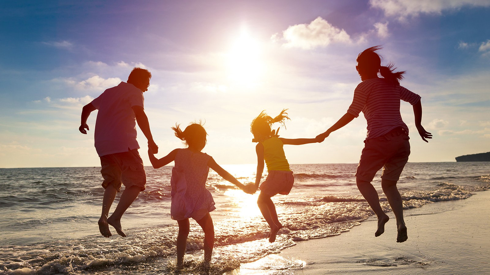 Família pulando na praia