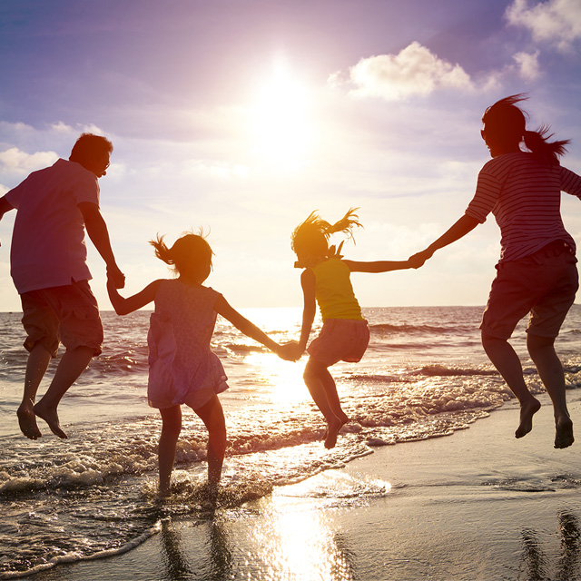 Família pulando na praia