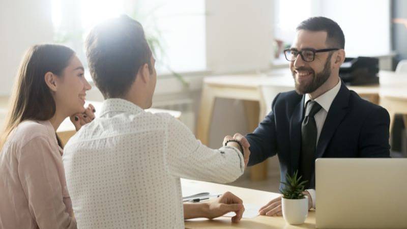 Homem atende um casal de consumidores