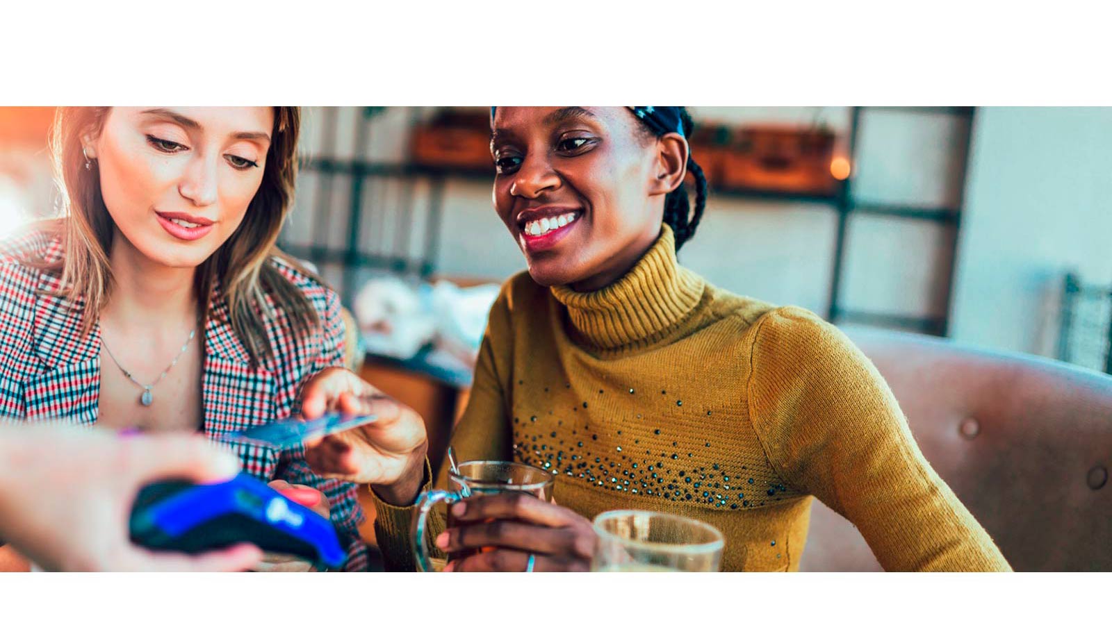 Duas mulheres pagando a conta de um café com cartão