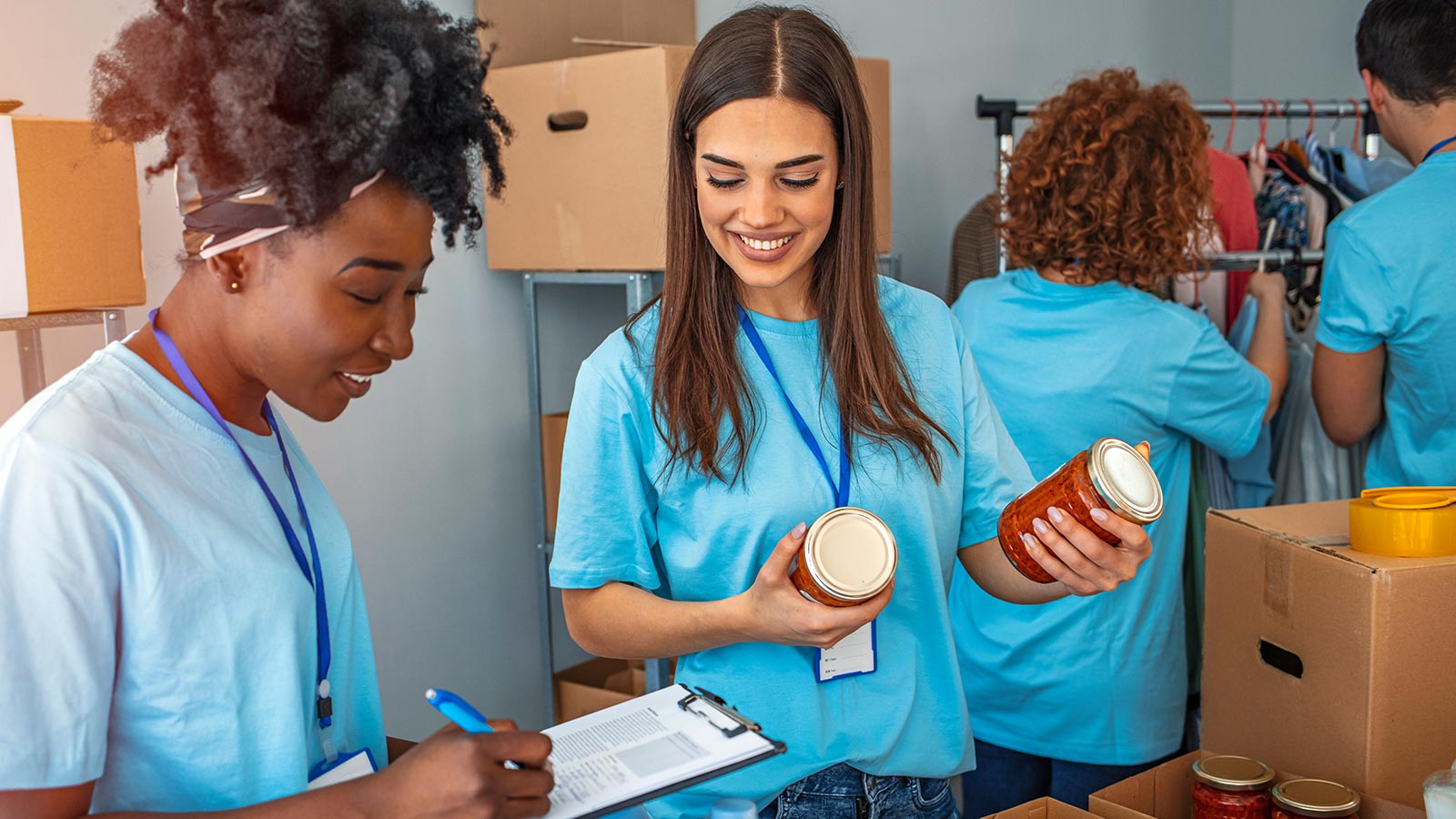 Mulheres desempacotando alimentos e anotando numa prancheta