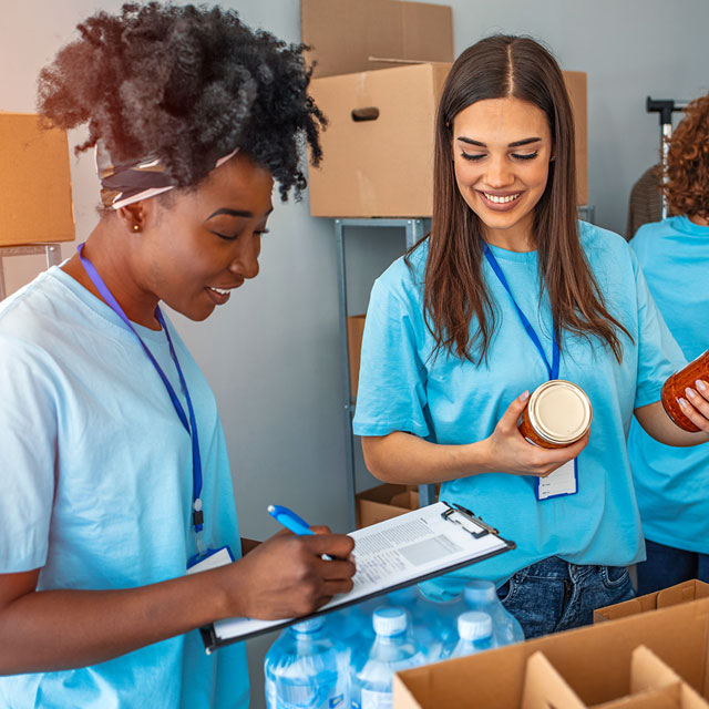 Mulheres desempacotando alimentos e anotando numa prancheta