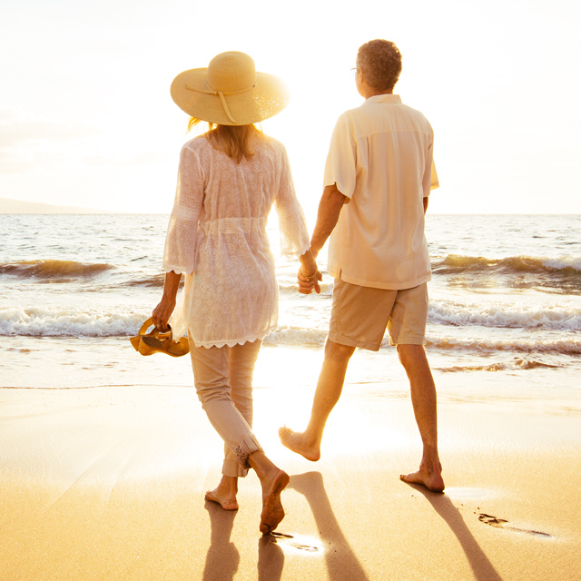 Casal caminhando de mãos dadas na praia