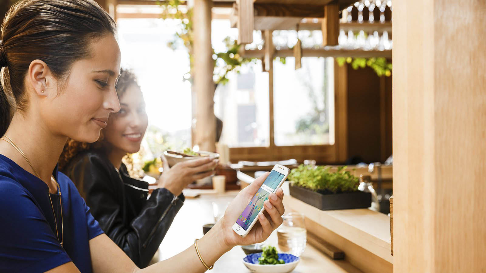 Cliente Visa utilizando seu smartphone em restaurante