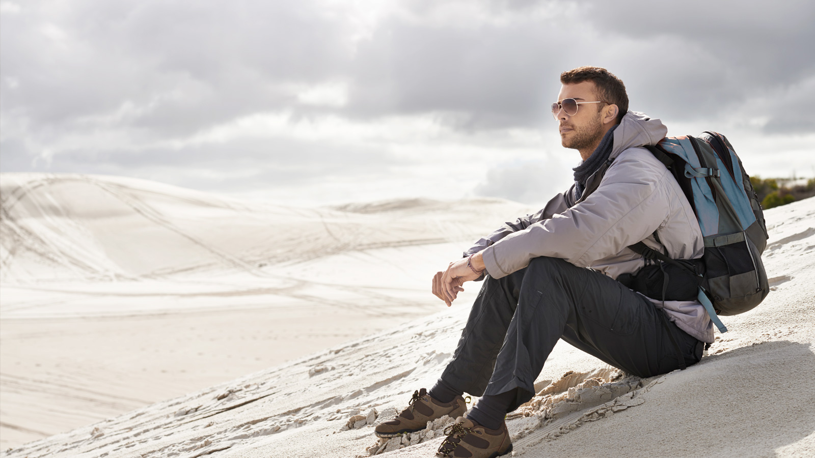 Homem sentado nas dunas