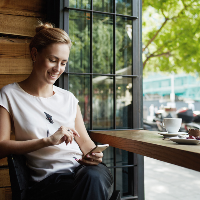 Mulher com celular num café