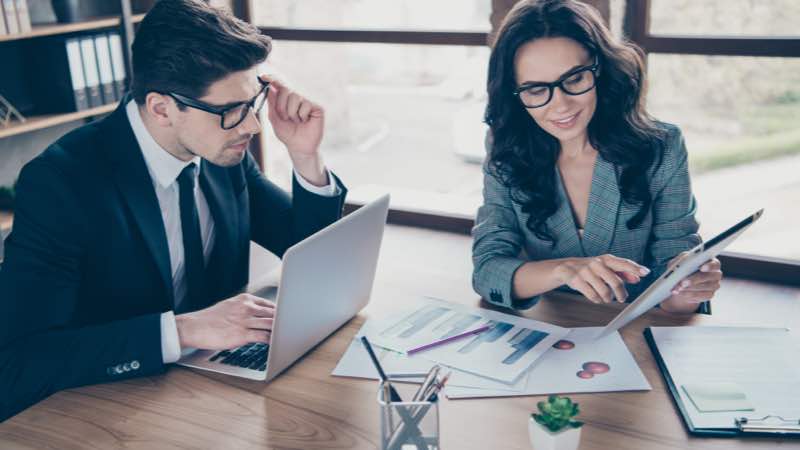 Homem e mulher de perfil corporativo analisando dados