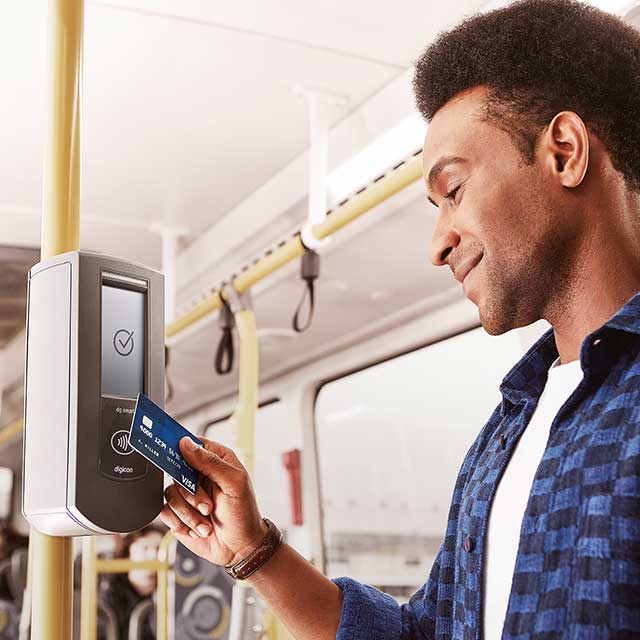 Homem aproximando seu cartão visa na catraca do ônibus