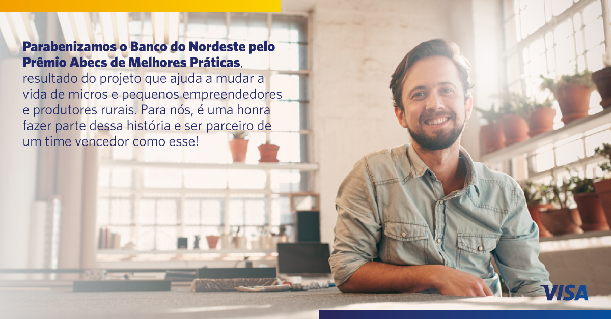 Fotografia de um homem sorrindo, cercado de vasos com plantas. A mensagem de parabenização da Visa ao BNB está sobre a imagem