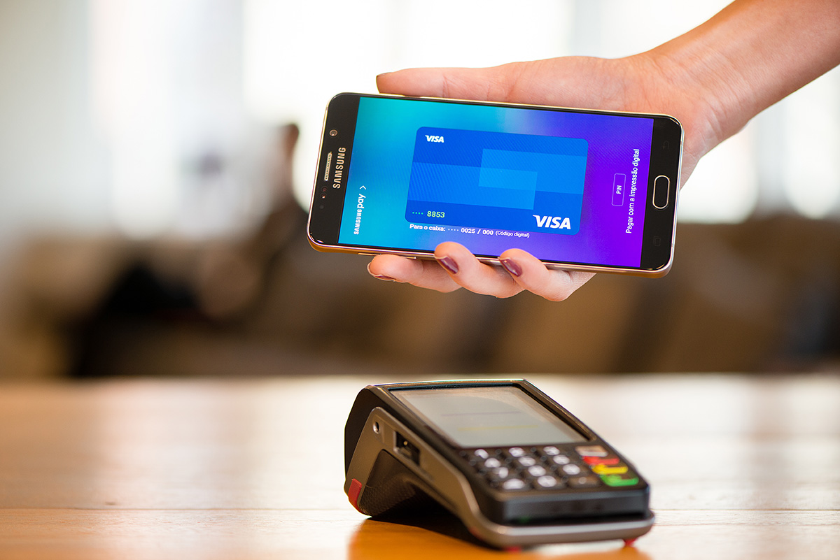 Pulseira Bradesco Visa Celular que faz pagamento por aproximação, com o cartão virtual aparecendo na tela