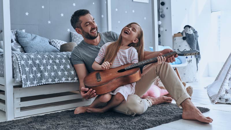 Pai e filha tocando violão