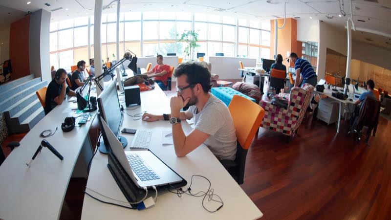 Visa Everywhere Initiative Várias pessoas trabalhando com notebooks e computadores em sala ampla