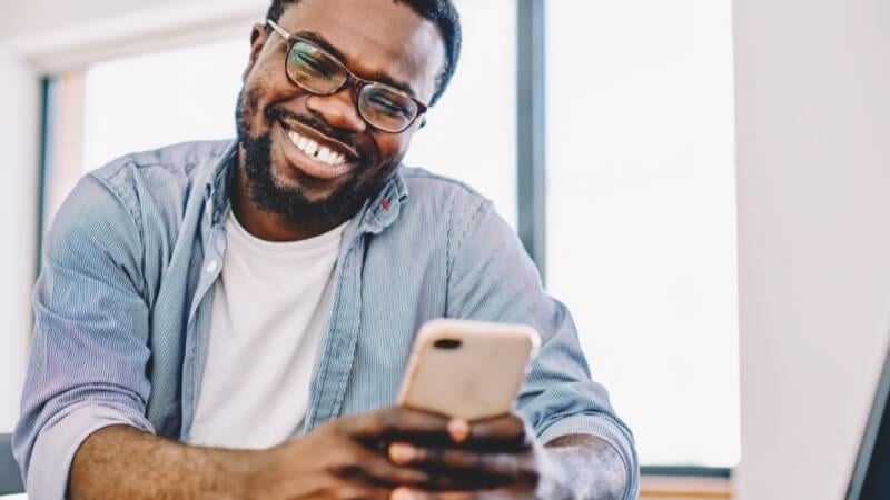 Homem sorrindo para o celular