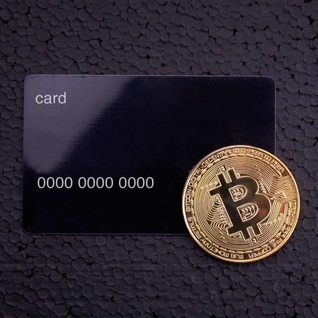 Imagem de um cartão com uma moeda digital ao lado
