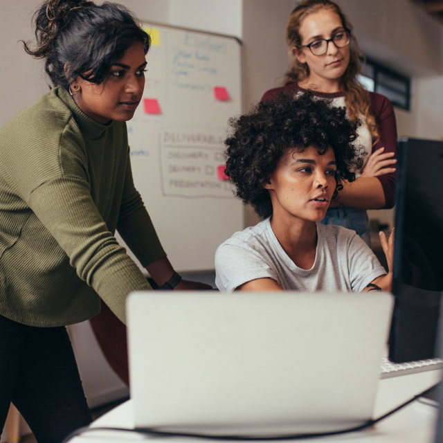 Imagem exibe três jovens participando de um desafio em frente ao computador
