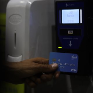 Usuário utilizando seu cartão visa no leitor de cartões.