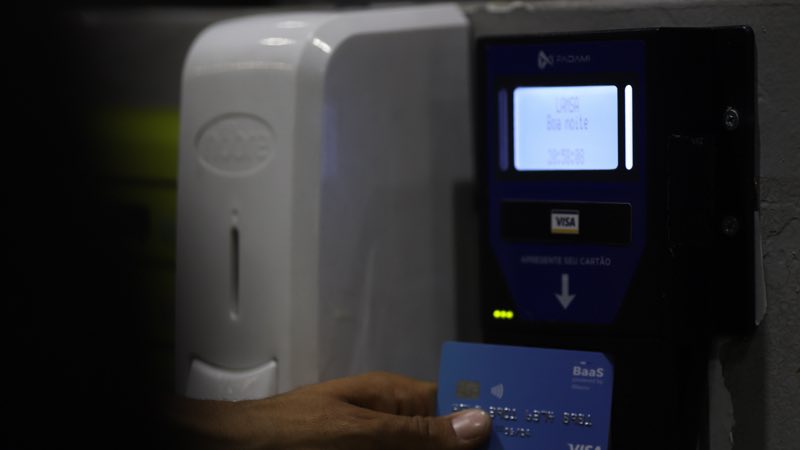 Usuário utilizando seu cartão visa no leitor de cartões.