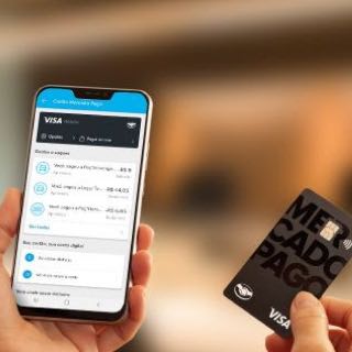 Pessoa com celular e cartão Mercado Pago Visa