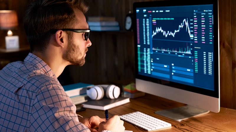 Homem analisando gráficos no computador