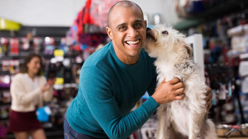 Homem abraçando cachorro.