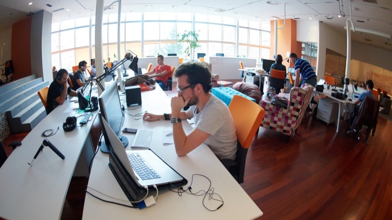 Imagem exibe um escritório com várias pessoas