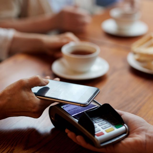 Cliente pagando por aproximação com celular.