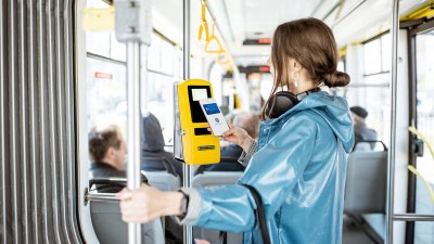 Imagem de uma mulher utilizando transporte público e pagando por aproximação com seu smartphone