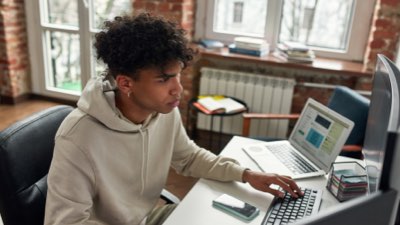 Imagem de um rapaz trabalhando em seu computador