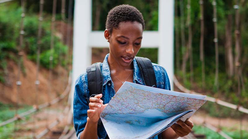 Imagem de uma mulher exploradora analisando um mapa em suas mãos 