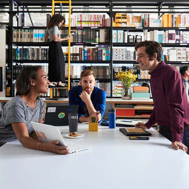 A group of four employees collaborating in a office space.